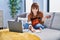 Young woman composing song playing ukelele at home