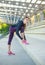 Young woman in concrete public stadium doing fitness stretching exercises, sports and healthy lifestyle