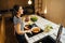 Young woman cooking a healthy meal in home kitchen.Making dinner on kitchen island standing by induction hob.Preparing fresh