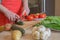 Young woman cooking healthy meal in the kitchen. Cooking healthy food at home. Woman in kitchen preparing vegetables. Chef cuts