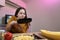 Young woman cooking in a kitchen. Housewife preparing vegetables for cooking. Girl put fresh fried meat into yellow zucchini.