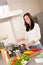 Young woman cooking tomato sauce in the kitchen