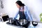 A young woman cooks while watches a video on a tablet