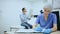 Young woman cosmetologist working with papers in modern clinic of aesthetic cosmetology, recording examination results