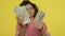 Young woman counting cash money in yellow studio. Rich girl counting money cash