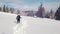 Young woman cross-country skiing on beautiful snowing day. Approaching wooden hut