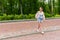 Young woman cross the footpath in a park