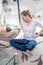 Young woman with crossed legs sitting with hands on hips