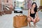 Young woman crouching alongside a suitcase