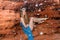 Young woman  in crown from shells sitting in the cave in red sand wall