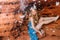 Young woman  in crown from shells sitting in the cave in red sand wall