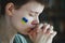 Young woman crying, Ukrainian flag symbol, stop the war