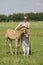 Young woman cuddling with her best friend, falcon color stallion foal, sharing love and mutual affection