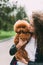 Young woman cuddling with her cute little poodle