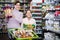 Young woman customer with girl looking for pasta in supermarket