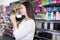 Young woman customer touching hair in cosmetics shop