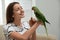 Young woman with cute Alexandrine parakeet