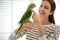 Young woman with cute Alexandrine parakeet