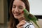 Young woman with cute Alexandrine parakeet