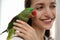 Young woman with cute Alexandrine parakeet on background