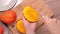 Young woman is cutting a beautiful fresh juicy mango to eat on a wooden table and chopping board in the kitchen, close up , 4K