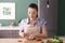 Young woman cutting parsley for salad in kitchen