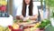 Young woman cutting spinach on wooden board