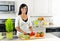 Young woman cutting vegetables in kitchen