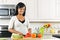 Young woman cutting vegetables in kitchen