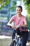 Young Woman Cycling Next To River In Urban Setting