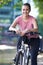 Young Woman Cycling Next To River In Urban Setting