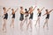 Young woman dance instructor teaching a ballet class to a group of a children in her studio. Ballerina teacher working