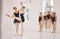 Young woman dance instructor teaching a ballet class to a group of a children in her studio. Ballerina teacher working