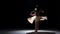 Young woman dancer dancing contemporary dance moves, on black, shadow