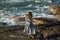 A young woman dances freely on the ocean coast.