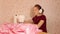 A young woman dances with headphones and at the same time sews on a sewing machine.