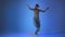 Young woman dancing house, energy jumps on blue background, studio shot