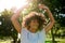 Young woman dancing in a park on a sunny afternoon