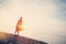 Young woman dancing at sunrise near ocean