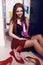 Young woman with dark hair posing in wardrobe room with lot of shoes