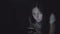 Young woman in the dark at night sits with a phone in social networks