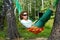 Young woman in dark sunglasses lies in hammock outdoors