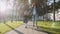 Young woman and daughter in school uniform walking in sunny weather, steadicam.