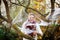 Young woman decorating home garden for halloween with spider web. Family celebrating holiday. Selective focus on web