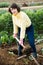 Young woman digs beds in the garden