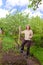 The young woman digs up a garden-bed