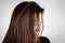 Young woman with dirty greasy hair on gray background.