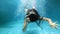 Young woman dives into the water. View from under the water, spray. Summer holiday concept, jump to the pool, Girl