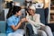 Young woman doctor health care worker medic nurse comforting older senior woman at home visit, patient suffering from clinical