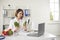 Young woman doctor nutritiologist showing fresh ingredients to patient online on laptop